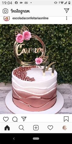 a white cake with pink flowers on top and the name caramel written in gold