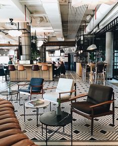 an office filled with lots of chairs and tables in front of a bar on top of a tiled floor