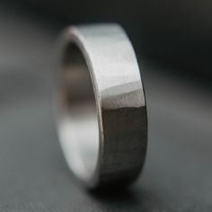 a close up of a wedding ring on a table with dark background and light reflection