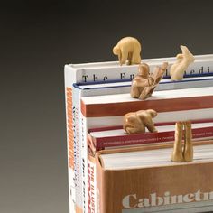 three books stacked on top of each other with figurines sitting on top of them