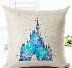 a pillow with a castle on it that has watercolor paint splatters all over it