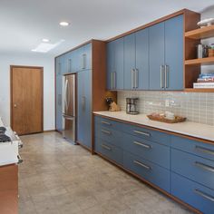 a kitchen with blue cabinets and white counter tops