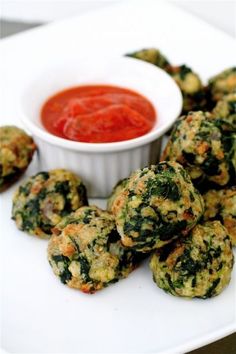 some broccoli fritters are next to a small bowl of ketchup