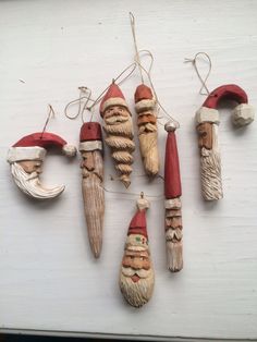 christmas ornaments are hanging on the wall with santa's hats and beards attached to them