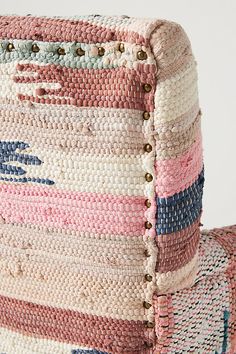 an upholstered chair made out of multicolored woven material with buttons on the back