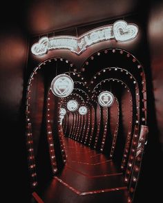 a long hallway with red carpet and lights on the walls that are shaped like hearts