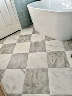 a bath tub sitting on top of a tiled floor