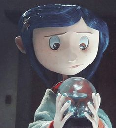 a close up of a doll holding a glass ball