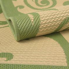 a close up view of a green and beige rug