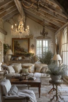 a living room filled with furniture and a chandelier hanging from the rafters