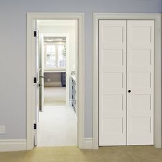 an empty room with two doors leading to another room