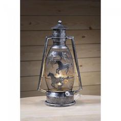 an old fashioned metal lantern with horses on it