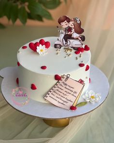 a wedding cake decorated with red and white flowers is on a table next to a notepad