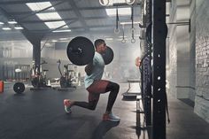 a man doing squats with a barbell in a gym