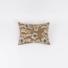 an orange and white pillow with flowers on it