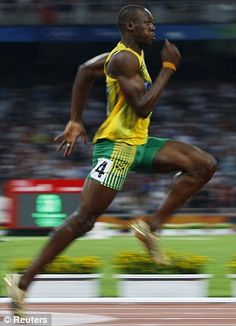 a man in yellow and green running on a track