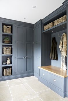 a large walk in closet filled with lots of blue cupboards and baskets on top of it