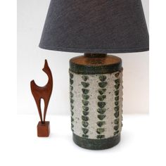 a lamp that is sitting next to a small wooden animal figure on a table top