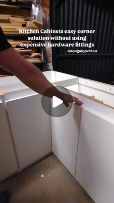 a person reaching into a kitchen cabinet that is being built