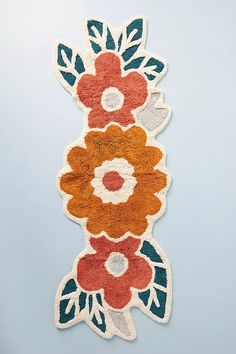 an orange and blue rug with flowers on it