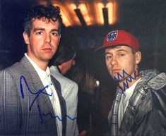 two men standing next to each other with autographs on their foreheads and one wearing a red hat