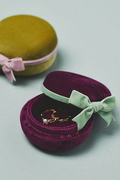 an open velvet ring box with a bow tie on it next to a gold ring