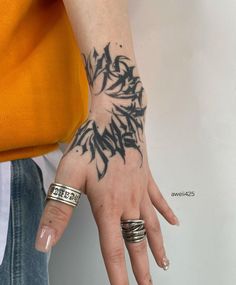 a woman's hand with black ink on it and two rings around her wrist