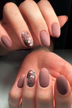 These oval-shaped nails feature a mix of elegant matte mauve hues and intricate floral designs. Two nails showcase a beautiful arrangement of pink and brown flowers with green leaves on a clear base, adding a touch of nature-inspired charm to the look. Perfect for autumn vibes!  // Photo Credit: Instagram @kyraenails Fall Natural Nails, Trendy Fall Nail Designs, Nails With Green, Short Round Nails, Tan Flowers, Oval Shaped Nails, Hand Stand, White Tip Nails, Fall Manicure