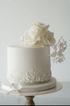 a white wedding cake with flowers on top