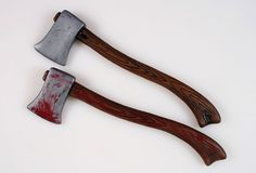 two axes with red paint on them sitting next to each other