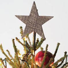 a wooden star on top of a christmas tree