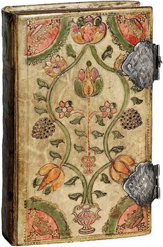 an old book is decorated with flowers and leaves on the cover, as if it were from a medieval manuscript