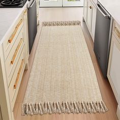 a kitchen with an area rug on the floor next to the stove and dishwasher