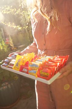 a woman holding a tray with snacks on it