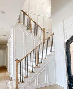 a white staircase with wooden handrails in a house