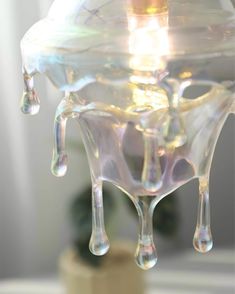 a water droplet hanging from a glass vase