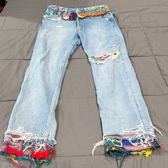 a pair of jeans that have been torn and are laying on a bed