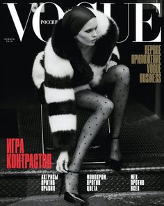 a woman in black and white is sitting on the cover of a magazine with her legs crossed