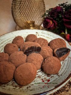 chocolate truffles on a plate with flowers in the background