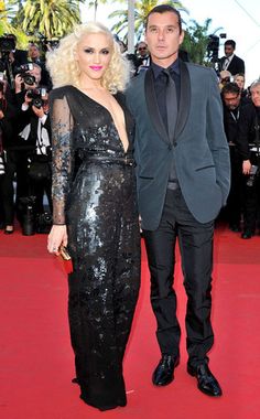 a man and woman standing next to each other on a red carpet at an event