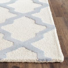 a white and blue rug on a wooden floor