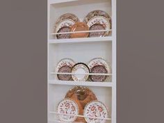 a white shelf filled with plates and bowls