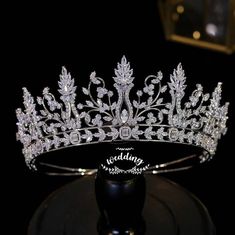 a tiara is displayed on a black stand in front of a dark background with the words wedding written across it