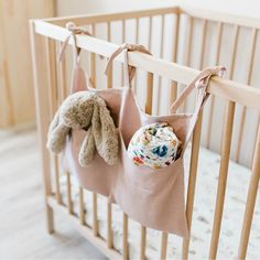 a baby crib with two stuffed animals hanging from it's side and the bottom half of the crib