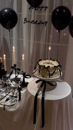 a table topped with a cake and balloons