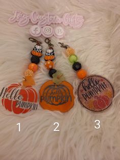 several charms are displayed on a white fur covered surface with the words hello, pumpkin, happy halloween