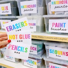 a person holding up some paper with words on it in front of plastic bins