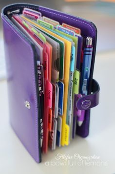 a close up of a wallet filled with lots of different colored pens and pencils