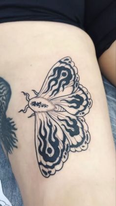 a woman's thigh with a butterfly tattoo on it