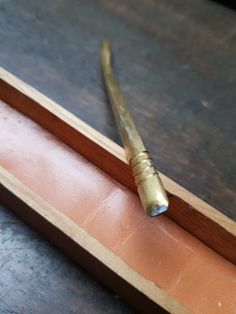 a pair of scissors sitting on top of a piece of wood